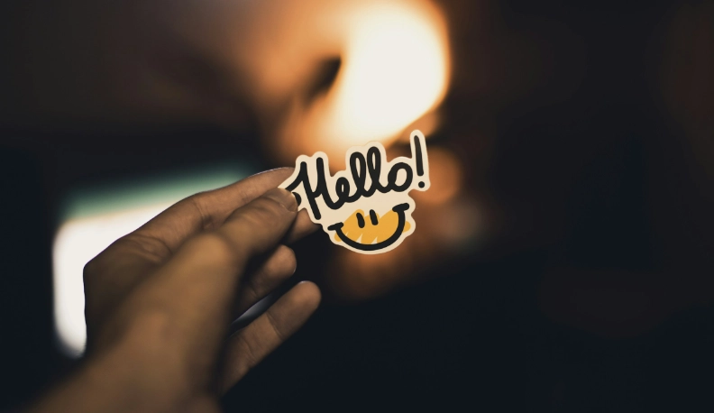 About us - person holding a print saying hello